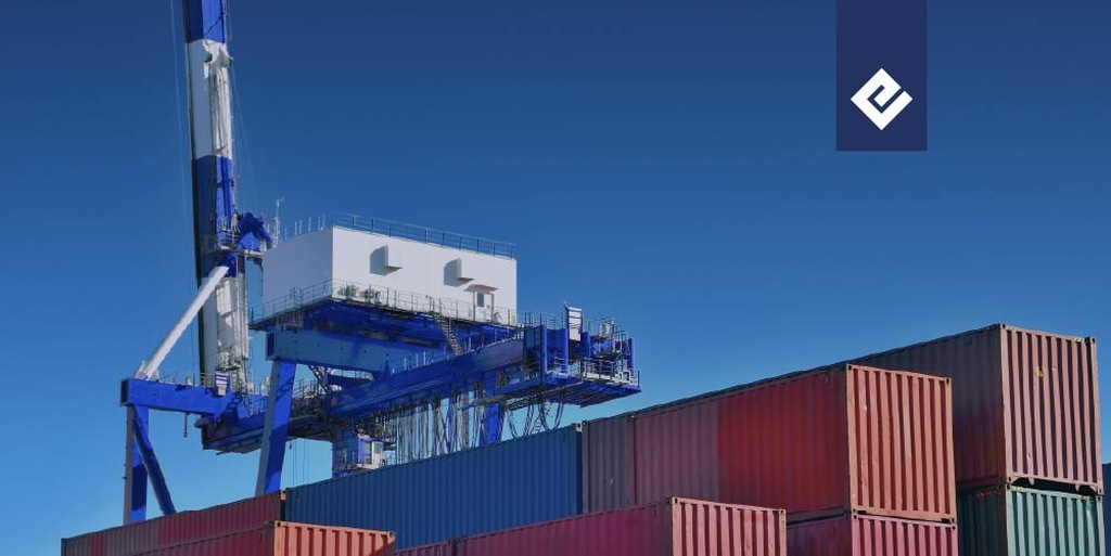 Operación de cadena de suministro en un puerto con contenedores apilados y grúa industrial, representando la logística y el transporte de mercancías.